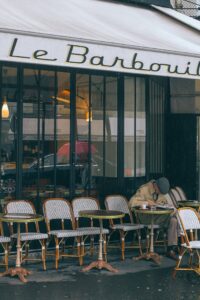 Unrecognizable man sitting at table in outdoor cafe